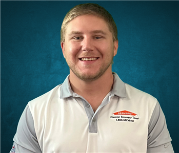 SERVPRO employee in front of a blue background